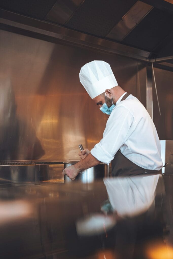 A chef writing on a clipboard in the kitchen